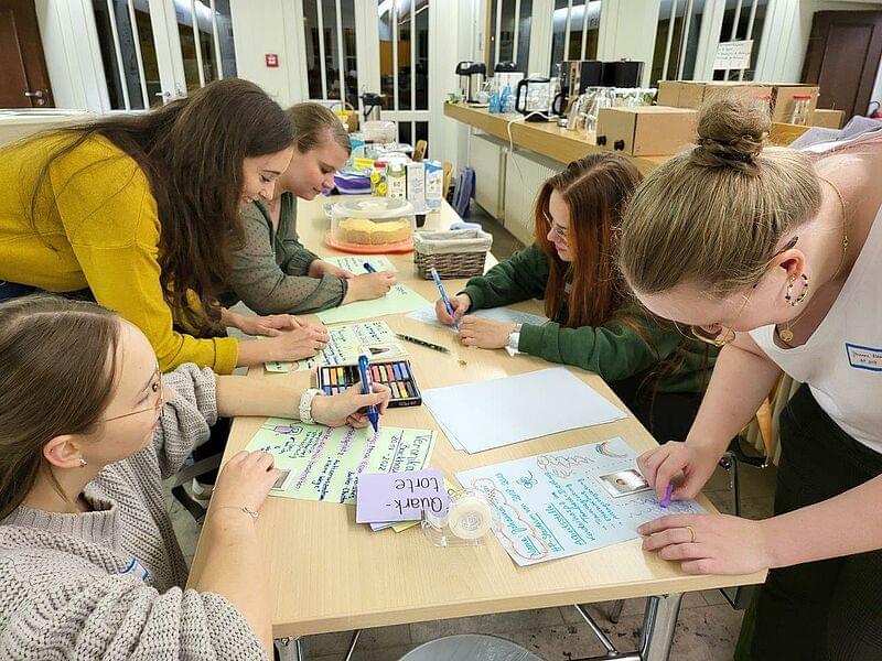 drei Studierende arbeiten an einem Tisch